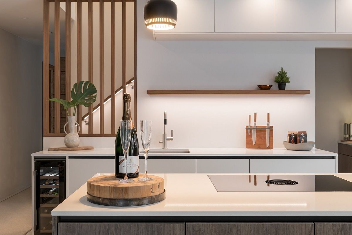 Spotlights on the ceiling just in front of the kitchen cabinets illuminate the cooking area